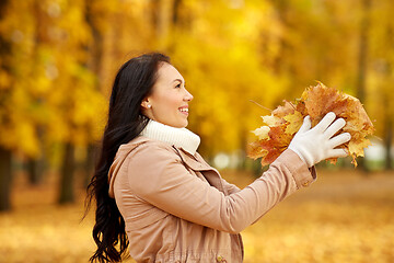 Image showing happy woman having fun with leaves in autumn park