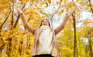 Image showing happy woman having fun with leaves in autumn park