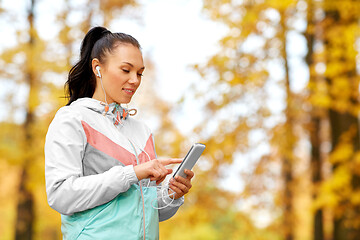 Image showing woman in autumn park and listening to music