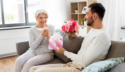 Image showing son giving present and flowers to senior mother