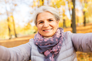 Image showing senior woman taking selfie at autumn park