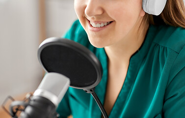 Image showing woman with microphone recording podcast at studio