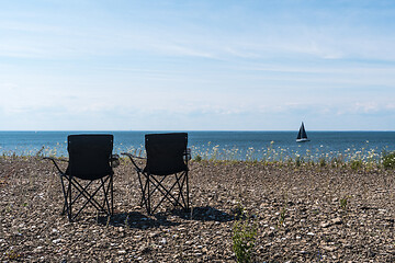 Image showing Two chairs by the coast