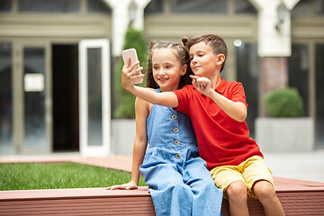 Image showing Two smiling kids, boy and girl taking selfie together in town, city in summer day