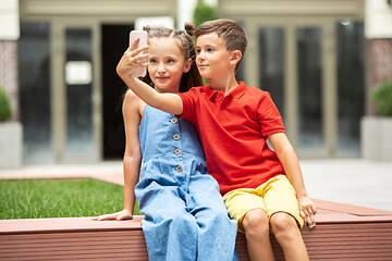 Image showing Two smiling kids, boy and girl taking selfie together in town, city in summer day