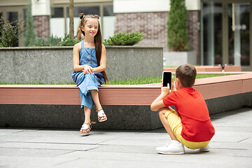 Image showing Two smiling kids, boy and girl taking photo together in town, city in summer day