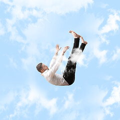 Image showing Mid-air beauty. Full length studio shot of attractive young man hovering in air and keeping eyes closed