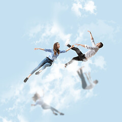 Image showing Mid-air beauty. Full length studio shot of attractive young woman and man hovering in air and keeping eyes closed