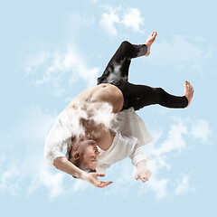 Image showing Mid-air beauty. Full length studio shot of attractive young man hovering in air and keeping eyes closed