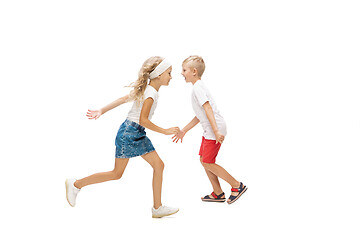 Image showing Happy little caucasian girl and boy jumping and running isolated on white background