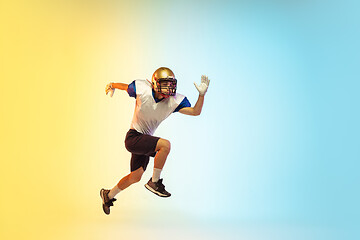 Image showing American football player isolated on gradient studio background in neon light