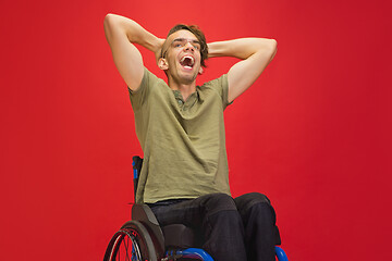 Image showing Caucasian young man\'s portrait isolated on red studio background. Human emotions concept