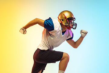 Image showing American football player isolated on gradient studio background in neon light