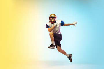 Image showing American football player isolated on gradient studio background in neon light