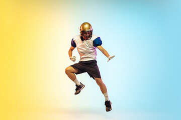 Image showing American football player isolated on gradient studio background in neon light