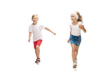 Image showing Happy little caucasian girl and boy jumping and running isolated on white background