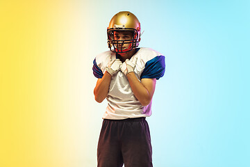 Image showing American football player isolated on gradient studio background in neon light