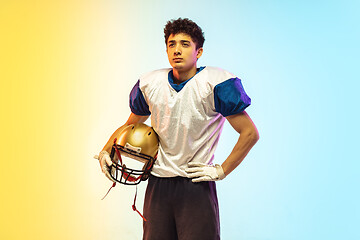 Image showing American football player isolated on gradient studio background in neon light