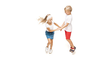 Image showing Happy little caucasian girl and boy jumping and running isolated on white background