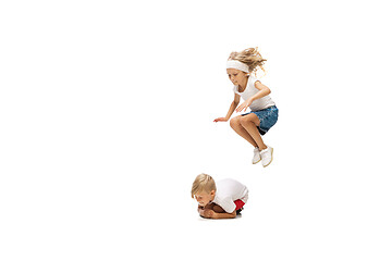 Image showing Happy little caucasian girl and boy jumping and running isolated on white background