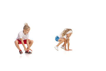 Image showing Happy little caucasian girl and boy jumping and running isolated on white background