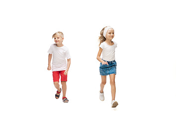 Image showing Happy little caucasian girl and boy jumping and running isolated on white background