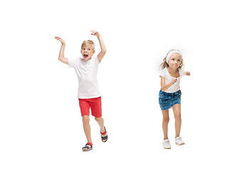 Image showing Happy little caucasian girl and boy jumping and running isolated on white background