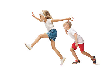 Image showing Happy little caucasian girl and boy jumping and running isolated on white background