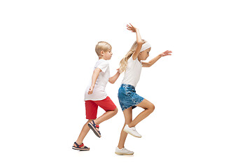 Image showing Happy little caucasian girl and boy jumping and running isolated on white background