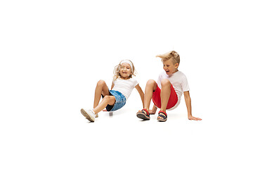 Image showing Happy little caucasian girl and boy jumping and running isolated on white background