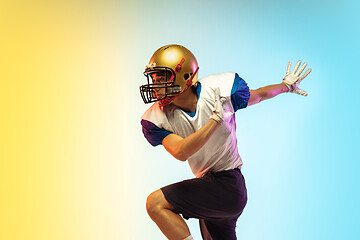 Image showing American football player isolated on gradient studio background in neon light