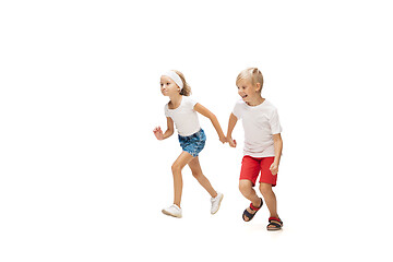 Image showing Happy little caucasian girl and boy jumping and running isolated on white background