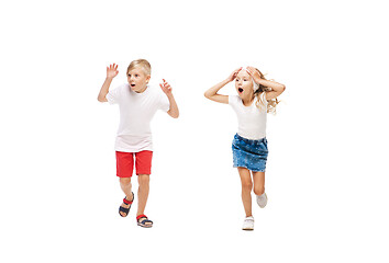 Image showing Happy little caucasian girl and boy jumping and running isolated on white background