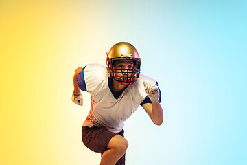 Image showing American football player isolated on gradient studio background in neon light