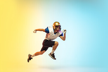 Image showing American football player isolated on gradient studio background in neon light