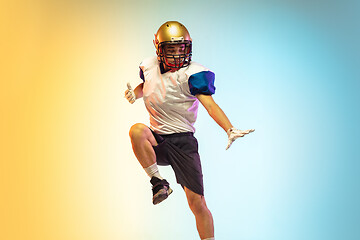 Image showing American football player isolated on gradient studio background in neon light