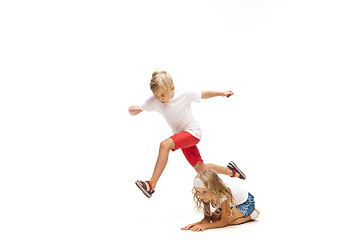 Image showing Happy little caucasian girl and boy jumping and running isolated on white background