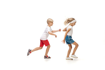 Image showing Happy little caucasian girl and boy jumping and running isolated on white background