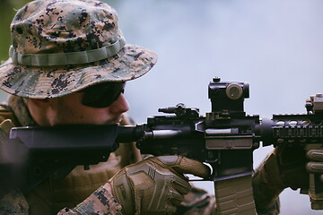 Image showing soldier in action aiming  on weapon  laser sight optics