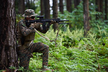 Image showing soldier in action aiming  on weapon  laser sight optics