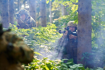 Image showing soldier in action aiming  on laser sight optics