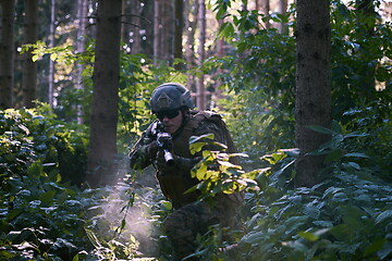 Image showing soldier in action aiming  on weapon  laser sight optics