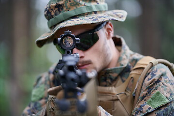 Image showing soldier in action aiming  on weapon  laser sight optics