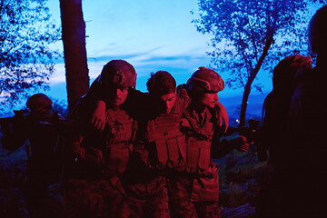Image showing military squad in action rescue wounded soldier