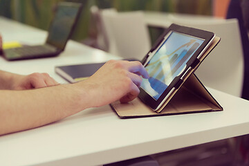 Image showing Closeup of mature hands holding tablet.