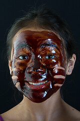 Image showing young asian girl having fun with a chocolate mask