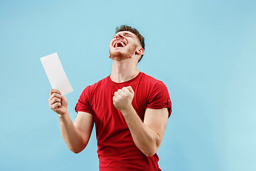 Image showing Young boy with a surprised expression bet slip on blue background