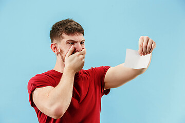 Image showing Young boy with a surprised expression bet slip on blue background