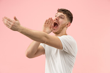 Image showing Isolated on pink young casual man shouting at studio