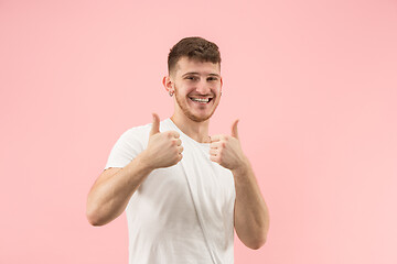 Image showing The happy businessman standing and smiling against pink background.